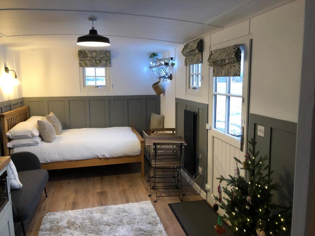 a bedroom with a bed and a christmas tree in it at Clay Bank Huts, Roseberry Shepherds Hut in Ingleby