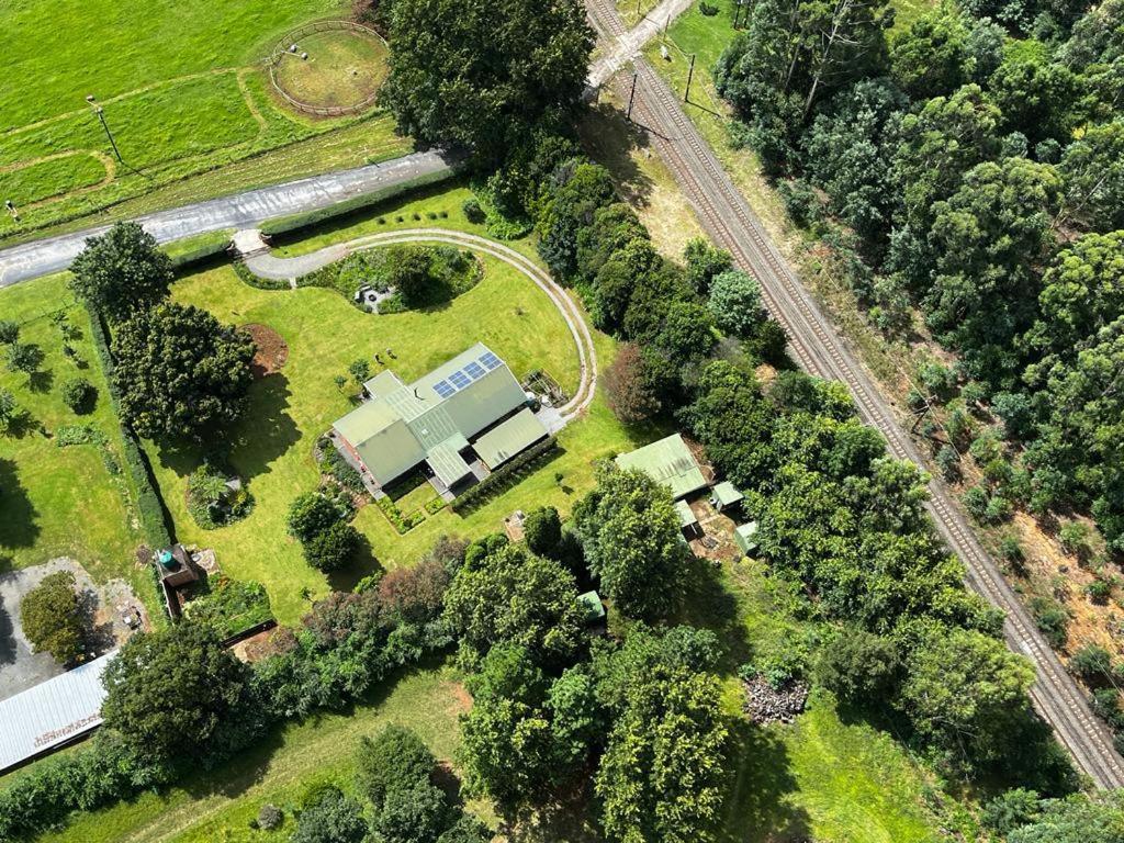 una vista aérea de una granja con un edificio y árboles en Green Acres Country House, en Lidgetton