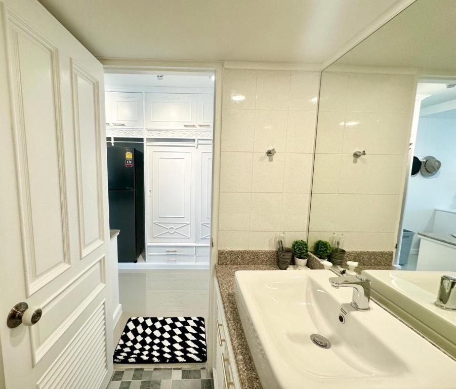 a white bathroom with a sink and a mirror at Mountain & City View Panorama at Nimman in Chiang Mai
