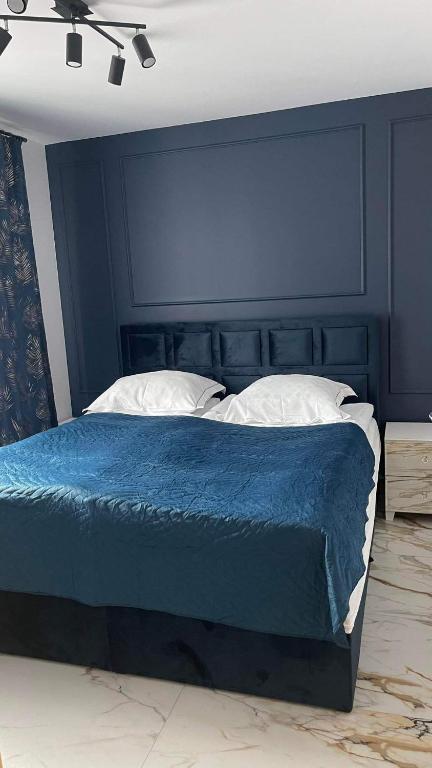 a bedroom with a bed with a blue head board at Apartament Niebieski 14/1 in Starogard Gdański