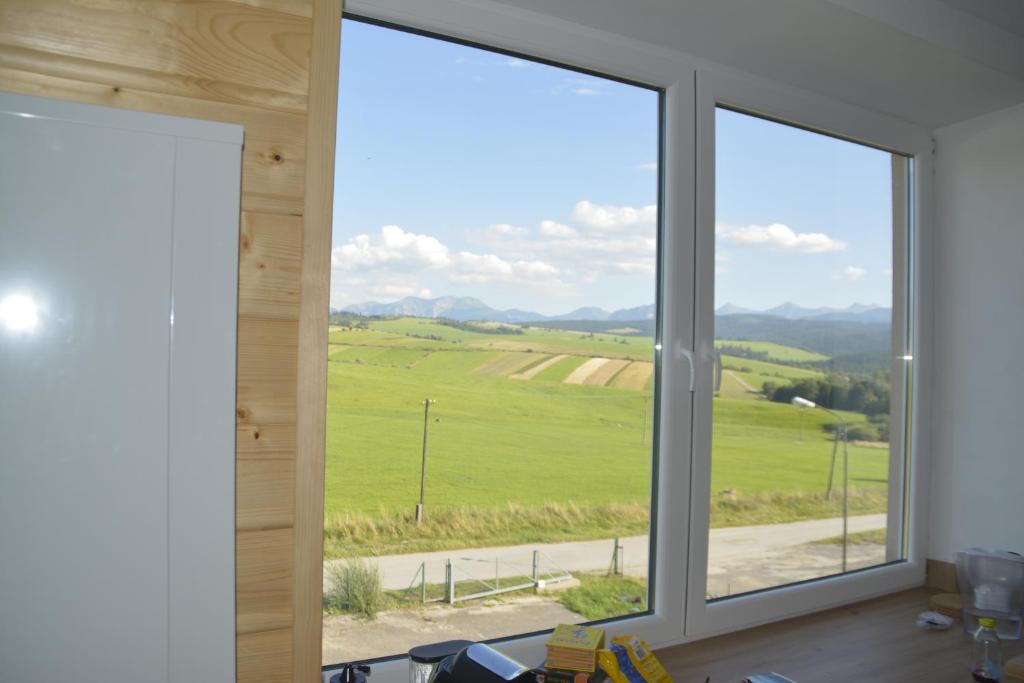 a room with a window with a view of a field at Apartament Oravski, blisko Term Chochołowskich, Tatry i Oravice, cisza, widok, parking in Suchá Hora