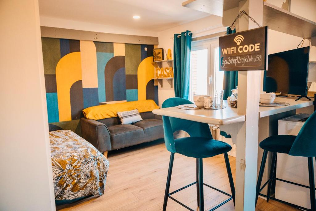 Zimmer mit einer Bar mit zwei blauen Stühlen und einer Küche in der Unterkunft Suite Lou _ Résidence Isaelle in Bray-Dunes