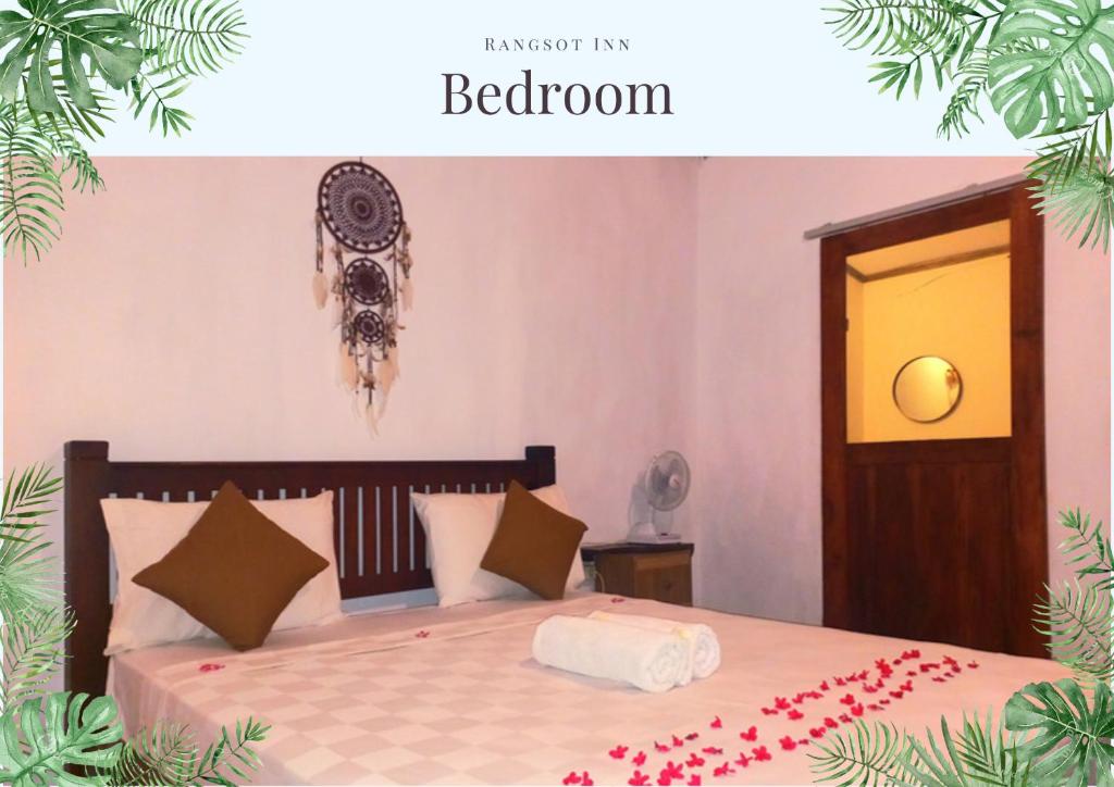 Un dormitorio con una cama con flores rojas. en Rangsot Inn en Pawenang