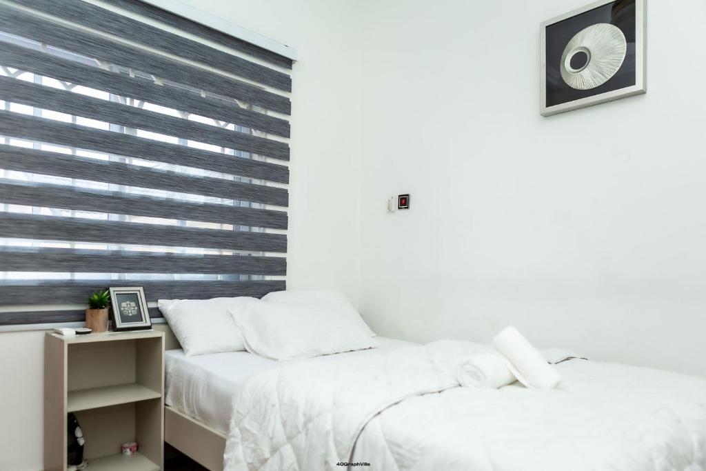 a bedroom with two beds and a window with blinds at Hallet Homes VIII - East Legon, Accra in Accra