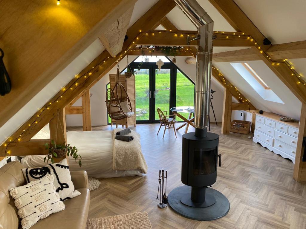 a living room with a fireplace in the attic at Bedport Loft in Burrington