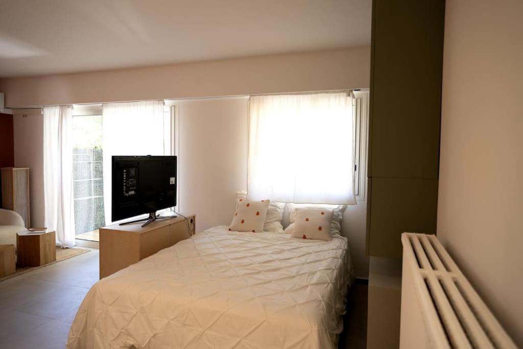 - une chambre avec un lit blanc et une télévision dans l'établissement Appartement avec jardin proche mer, à Antibes