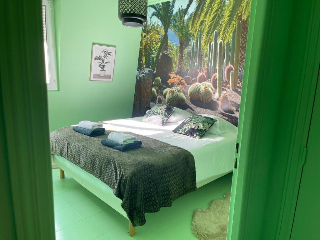 a bedroom with a bed with a mural of a cactus at luxury Magic Cactus Garden, Paris 0rly avec jacuzzi in Vigneux-sur-Seine