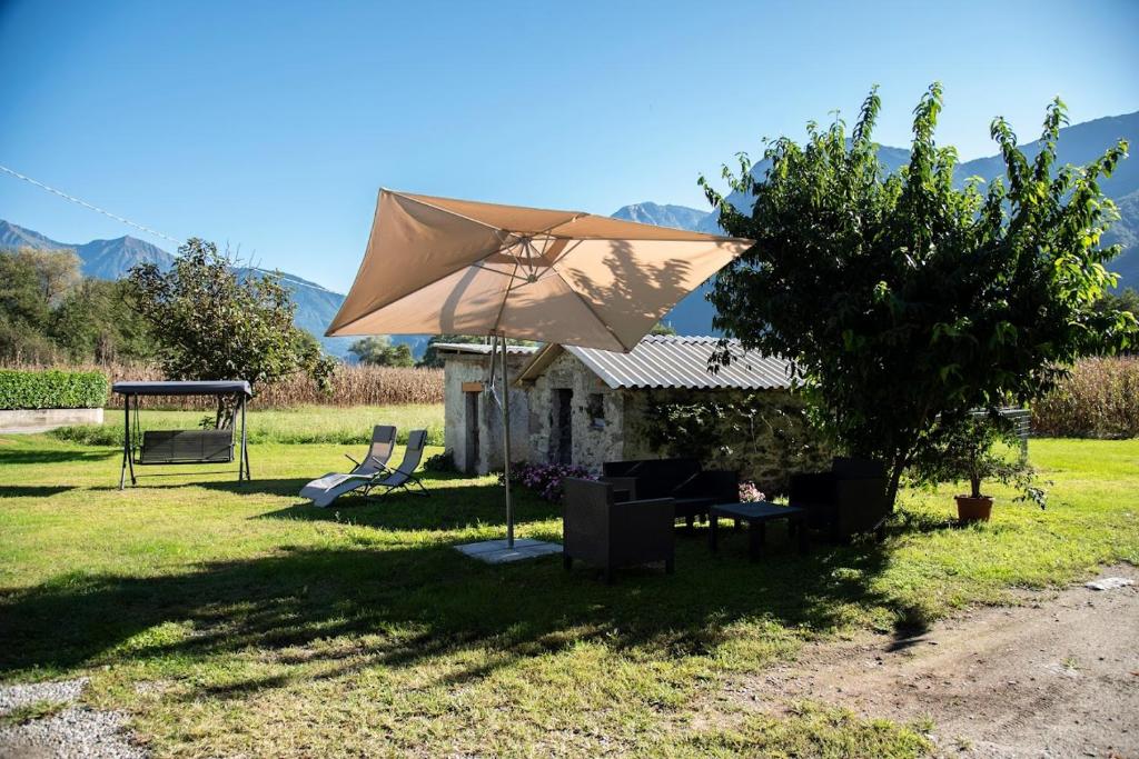 a picnic shelter with an umbrella in the grass at Cascina Pirondini in San Cassiano