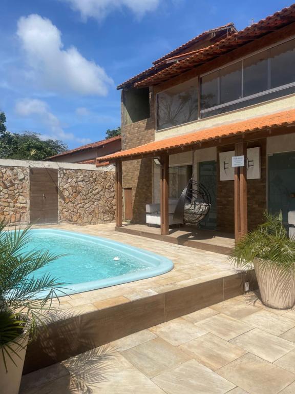 a swimming pool in front of a house at Pousada Bon Vivant in Cabo Frio