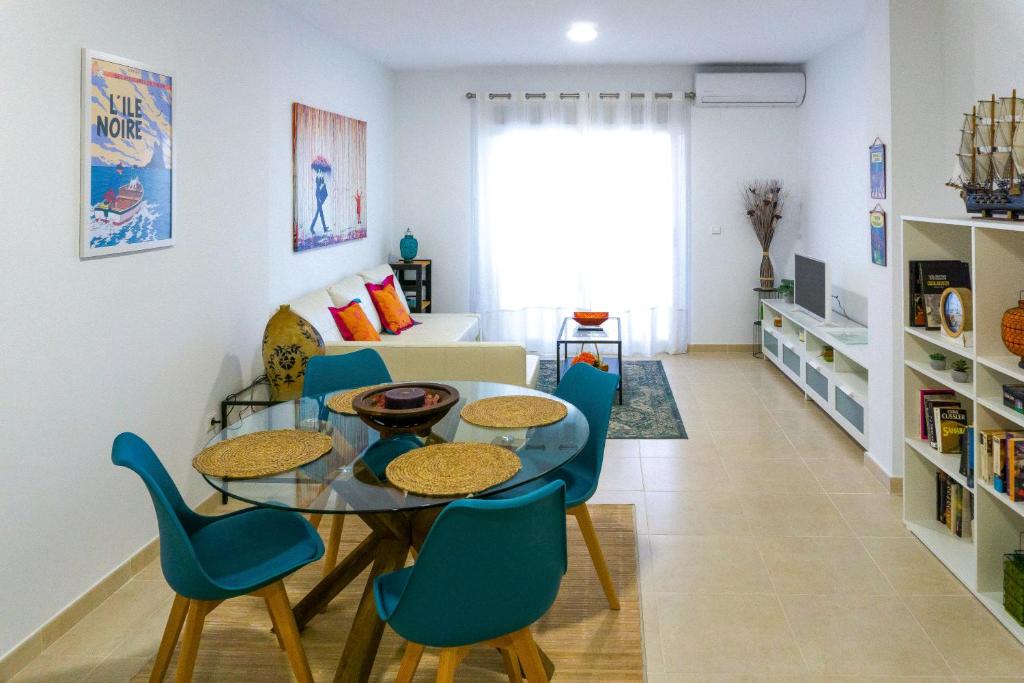 a living room with a table and chairs and a couch at Estupendo apartamento en el grao in Gandía