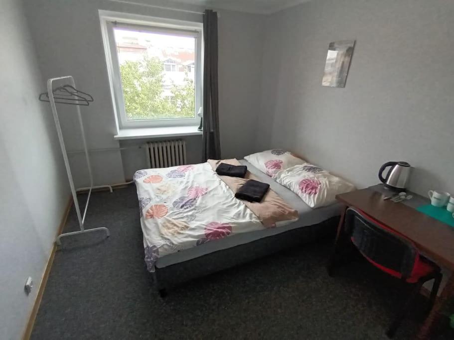 um quarto com uma cama, uma secretária e uma janela em Fantastic - NW30 Room C em Varsóvia