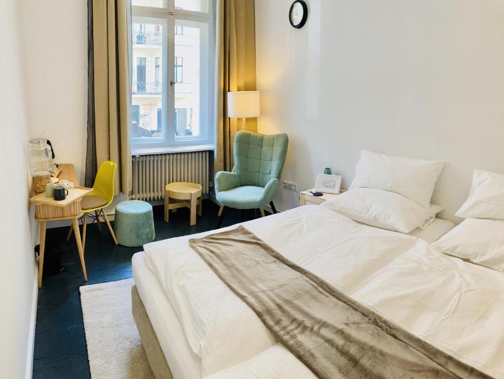 a bedroom with a white bed and a chair at Serviced Room im Herzen Berlin‘s in Berlin