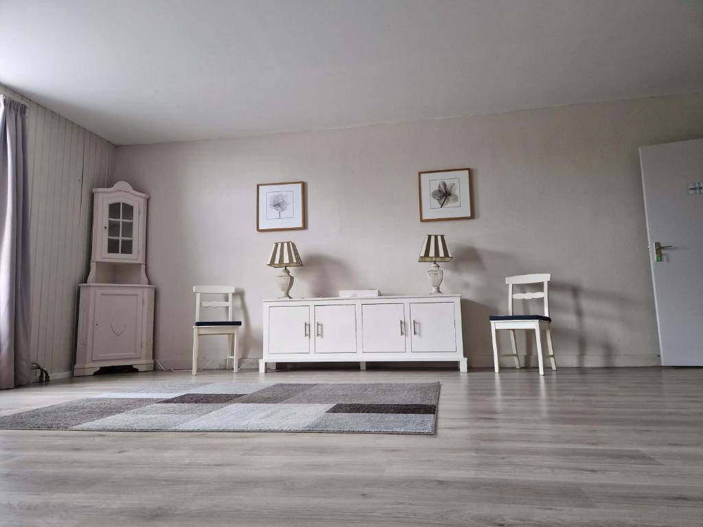 a living room with a white cabinet and two chairs at B&B 't Kloaster kamer Het Landhuis in Hulsberg