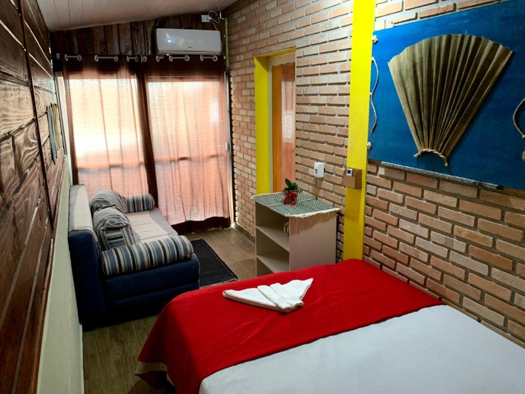 Hostel Vento Leste في بومبينهاس: غرفة صغيرة بها سرير وكرسي