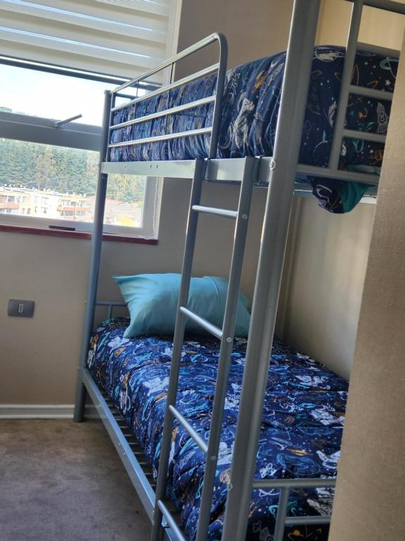 a bedroom with two bunk beds in a room at Departamento San Pedro de la Paz in San Pedro de la Paz