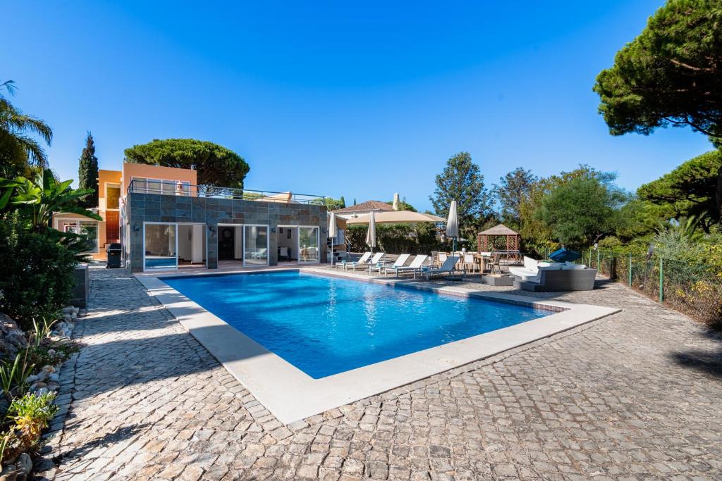 una piscina en el patio trasero de una casa en Villa Sea, Sun and Golf in Vilamoura en Quarteira