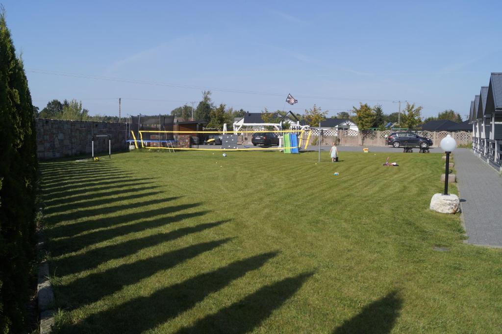 a grassy field with people playing a game of soccer at Domki Letniskowe Kraina Jodu in Bobolin