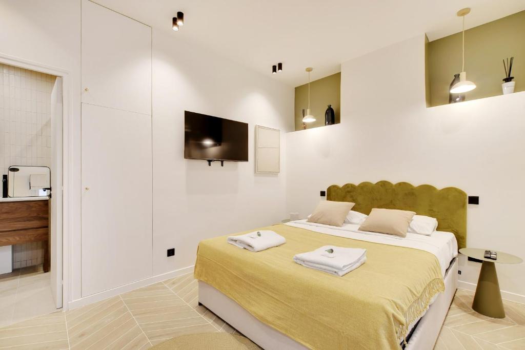 une chambre avec un lit avec deux serviettes dessus dans l'établissement Saint Ambroise Cosy suit 2P 1BDR, à Paris