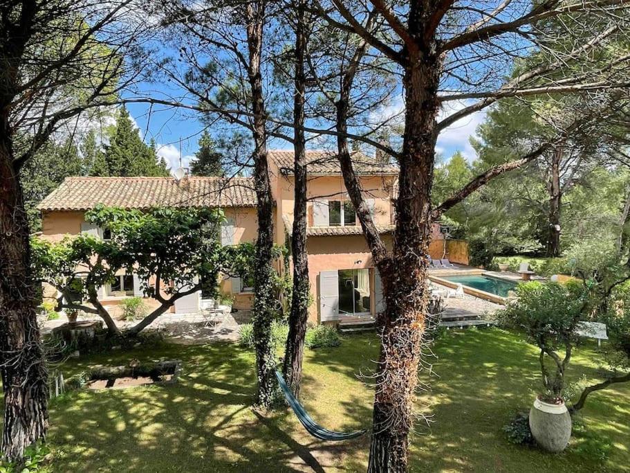 una casa con una manguera delante de un patio en Mas de Clary - propriété de caractère avec PISCINE, en Roquemaure