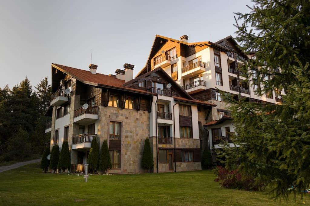 a large apartment building with a grassy yard at Mountain Apartment in Borovets Ski Resort in Borovets