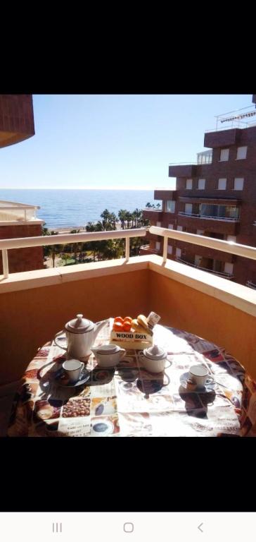 a table on a balcony with a view of the ocean at Acapulco II, 1a LINEA, Playa Amplaries in Oropesa del Mar
