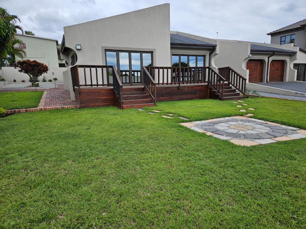 a house with a deck and a grass yard at Vintage@1420 in Ngodini