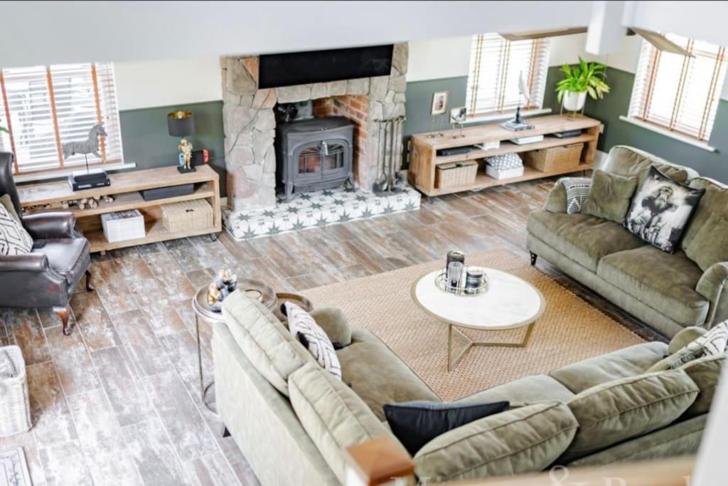 a living room with two couches and a fireplace at Rayners Farm Lodge in Mattishall