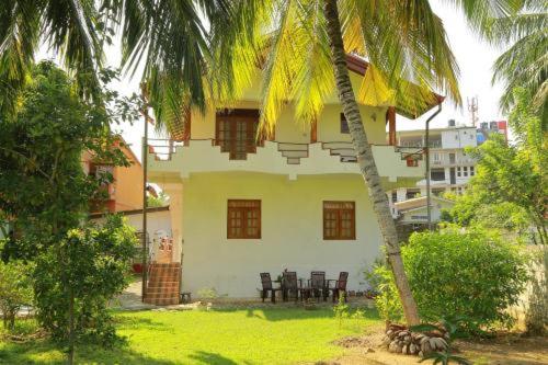 a house with a palm tree in front of it at 31 sea view in Tangalle