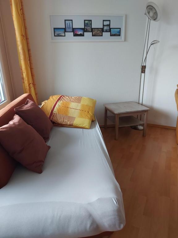 Schlafzimmer mit einem Bett mit Kissen und einem Tisch in der Unterkunft Rosenalm App 23 in Scheidegg