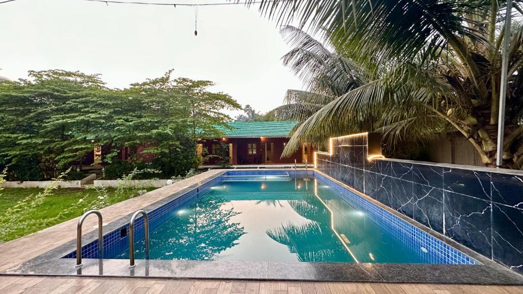 a swimming pool in the backyard of a house at Hrishivan Resort Nagaon in Nagaon