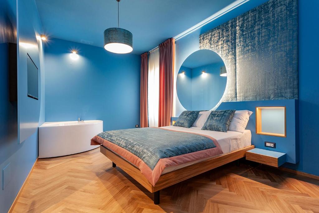 niebieska sypialnia z łóżkiem i lustrem w obiekcie Le Texture Premium Rooms Duomo-Cordusio w Mediolanie