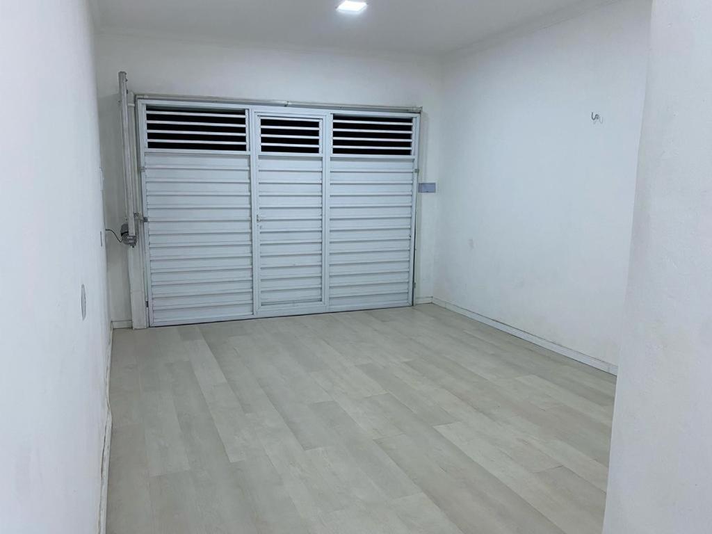 una stanza vuota con una porta del garage e un pavimento in legno di Alemanha aconchego a São Luís