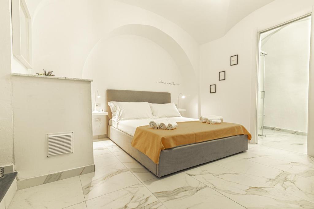 - une chambre blanche avec un lit et des serviettes dans l'établissement Dimora Bianca, à Catane