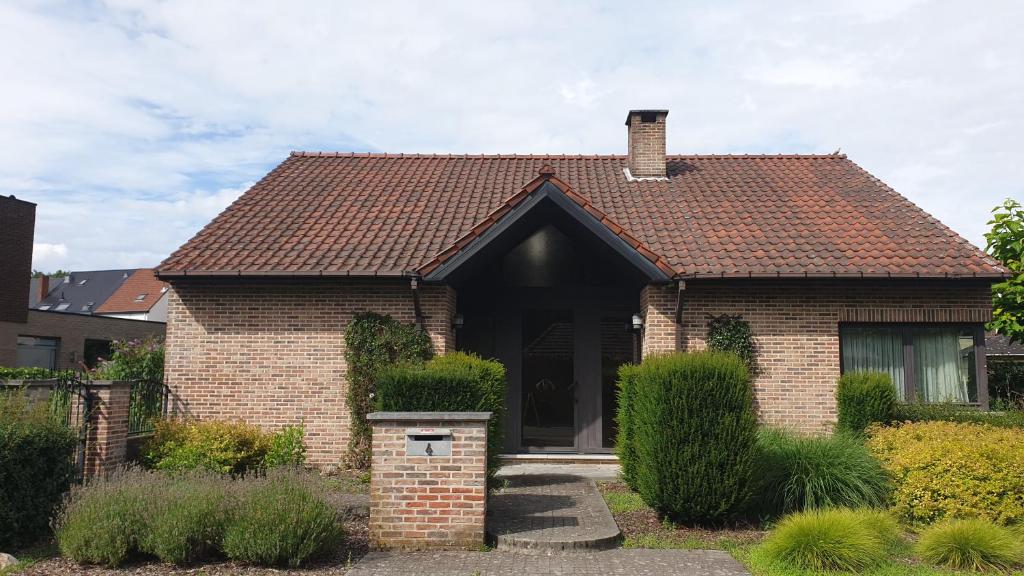 a brick house with a brown roof at Brelaarheide in Aan de Wolfsberg