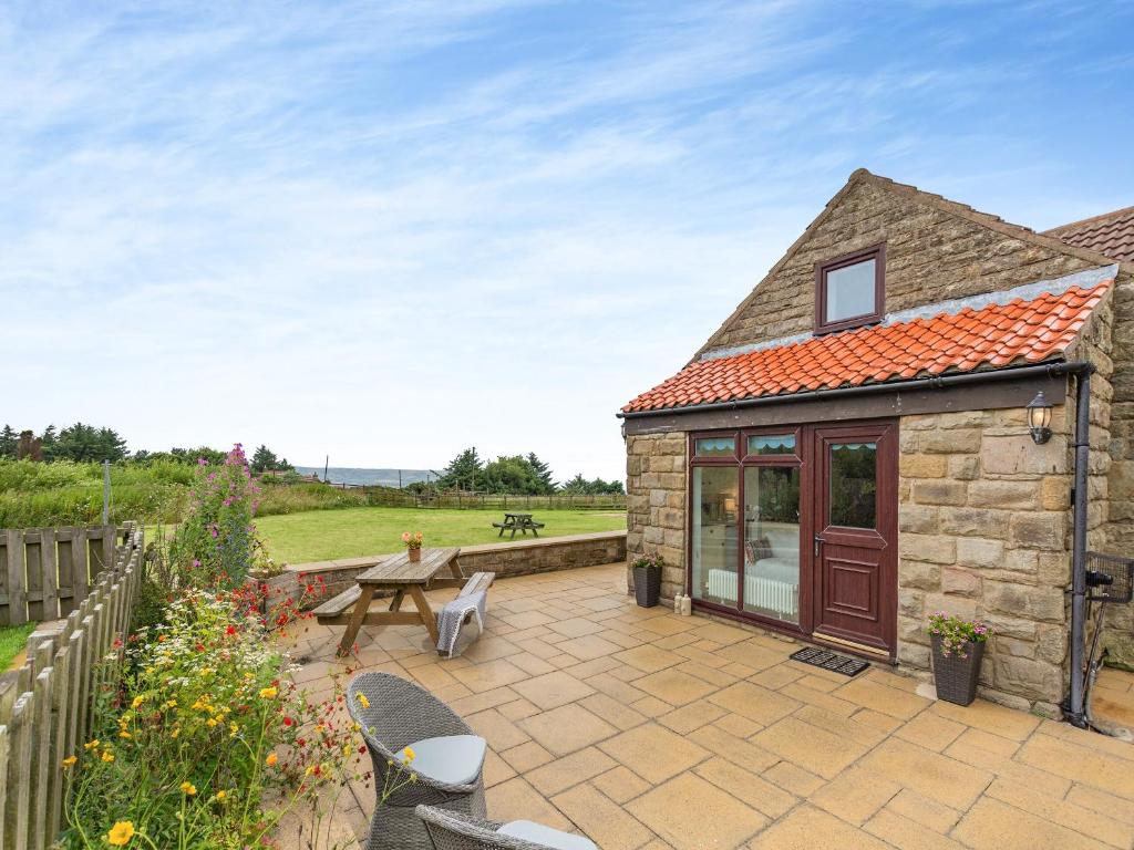 a stone house with a patio and a table at Beacon - Uk44719 in Ravenscar