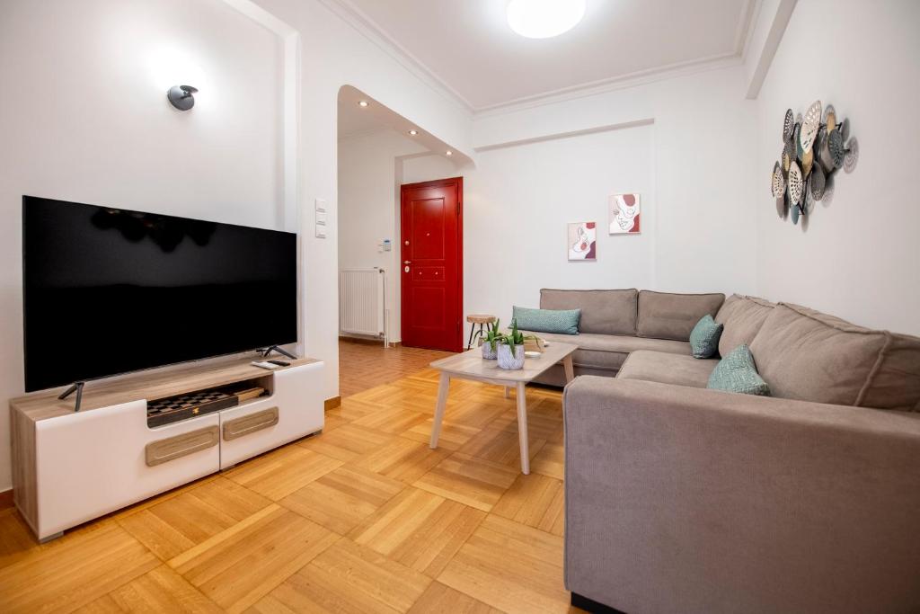 a living room with a couch and a flat screen tv at AinCAC Apartment Athens Center in Athens