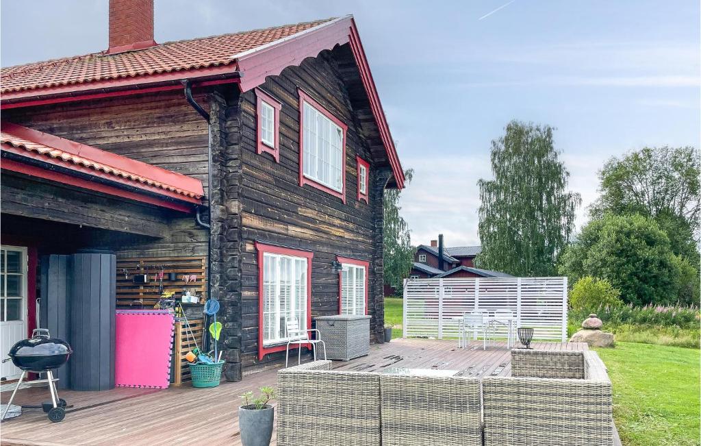 a house with a wooden deck with a grill at Lovely Home In Mora With Sauna in Mora