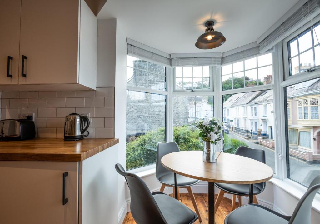 een keuken met een tafel en stoelen voor een raam bij Ty Llwyd Apartments - Poppit in Saint Dogmaels