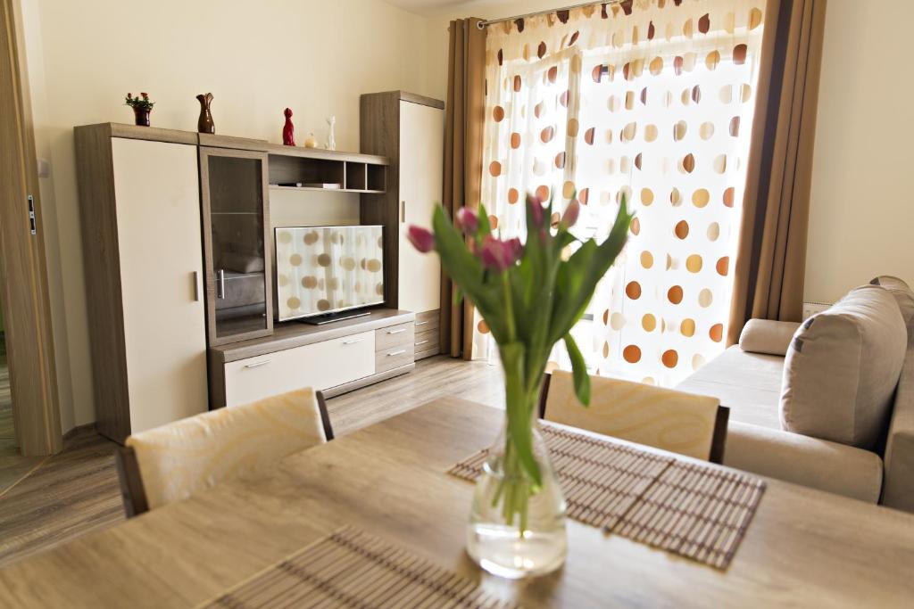 a vase of flowers on a table in a living room at Apartament MAJA Giżycko Żeglarska in Giżycko