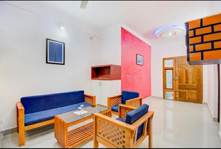 a living room with a blue couch and a table at Coorg Vacation Stay(KKR) in Madikeri