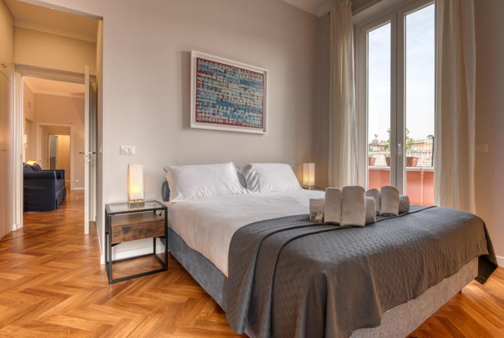 sypialnia z dużym łóżkiem i dużym oknem w obiekcie Top View Luxury apartment Piazza del Popolo w Rzymie