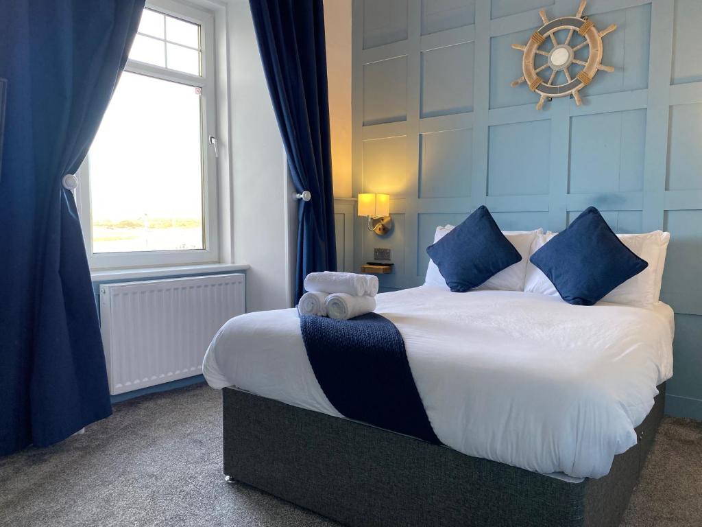 - une chambre avec un grand lit aux murs bleus et une fenêtre dans l'établissement Marina View Guest House, à Irvine