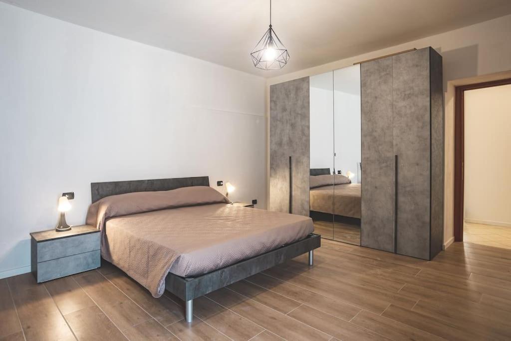 a bedroom with a bed and a large sliding glass door at Al Torrente Apartment [Monza - Milano] + free Wifi in Seveso