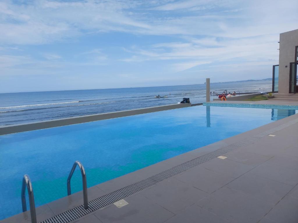 a swimming pool with a view of the beach at TANA Beach Villas in Lian