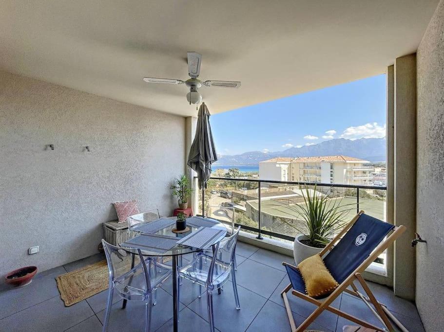 une pièce avec une table et des chaises et une grande fenêtre dans l'établissement Appartement vue mer au cœur de Calvi, à Calvi