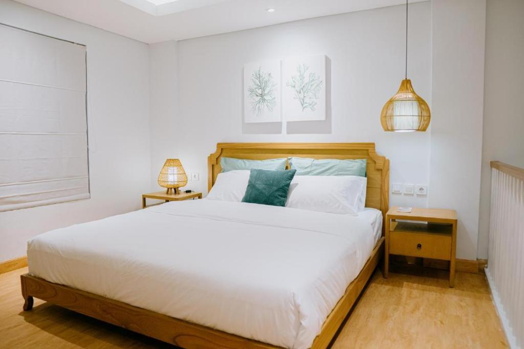 坎古的住宿－Casa Amarta - Canggu，卧室配有一张白色大床和两盏灯。