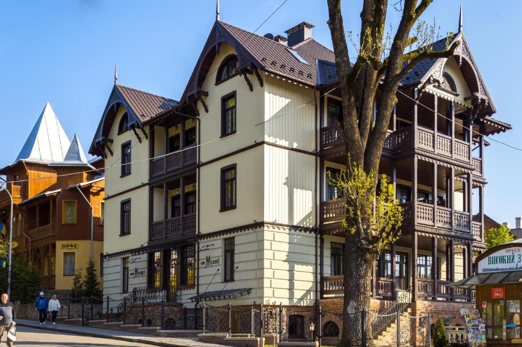 a large white building with a tree in front of it at Villa Mozart in Truskavets