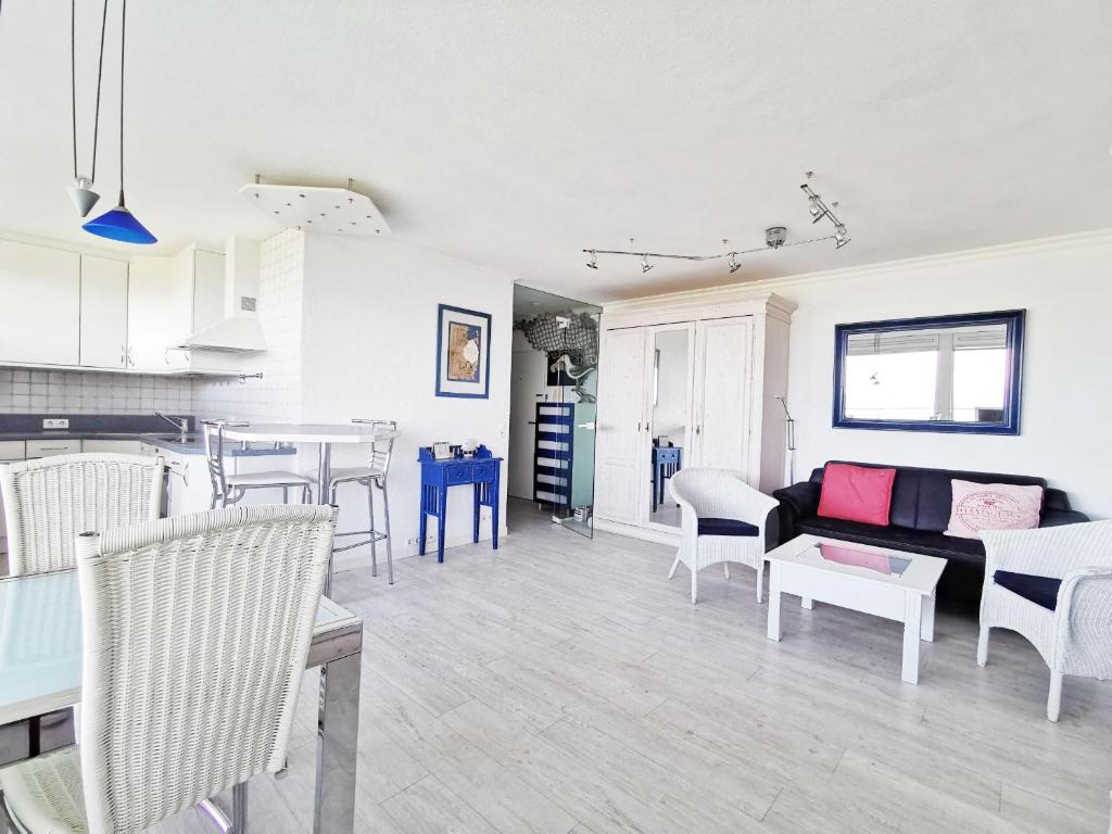 ein Wohnzimmer und eine Küche mit einem Sofa und Stühlen in der Unterkunft Haus Nordseeblick Nordseeblick, 1 in Norderney
