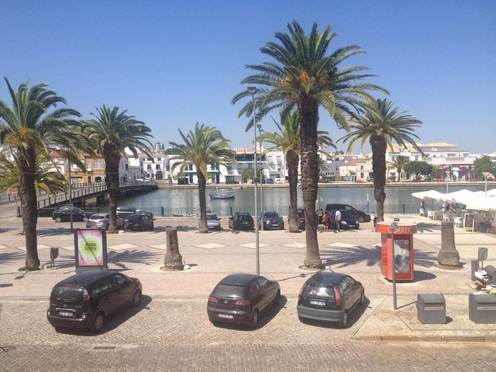 three cars parked in a parking lot with palm trees at Taah Billa Guest House in Tavira