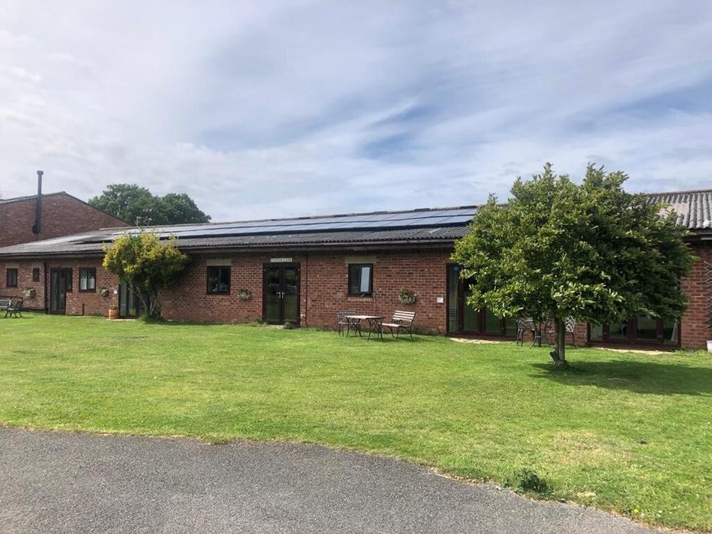 a brick building with a grass yard in front of it at Formby Point in Liverpool
